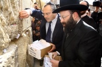 Rabbi of the Western Wall Shmuel Rabinowitz (right) and Aviv Hochman, general manager of the Israel Postal Authority, place letters addressed to God in cracks of the Western Wall, one of Judaism's holiest sites. Photo courtesty of Sasson Tiram/Israel Postal Authority
