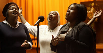(RNS2-JAN14) Left to right, Tonya Bates, Darcia Solomon and Tinishia Hunter sing at the Body of Christ Assembly, which leases space at the  Park Synagogue in Cleveland Heights, Ohio.  Church and synagogue leaders hope for better black-Jewish relations. For use with RNS-BLACKS-JEWS, transmitted Jan. 14, 2009. Religion News Service photo by Lynn Ischay/The Plain Dealer. 