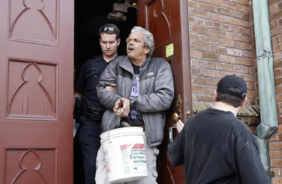 (RNS2-JAN09) Harold Baquet, one of several Catholics who occupied the shuttered Our Lady of Good Counsel Church in New Orleans, is led out of the church by New Orleans police. For use with RNS-NOLA-EVICT, transmitted Jan. 7, 2009. Religion News Service photo by Eliot Kamenitz. 