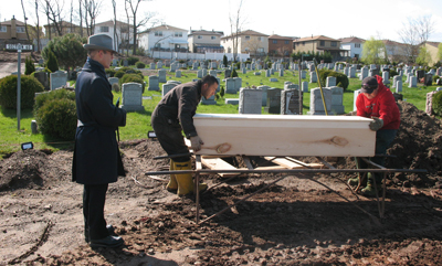 (RNS1-APR28) Rabbi Shmuel Plafker, left, of the Hebrew Free Burial Association recites blessings on the pine coffin of Leonard Horowitz at the Mount Richmond Cemetery on Staten Island, N.Y. Plafker's group paid for the funeral when Horowitz died without any money or survivors. Plafker said requests for the group's services are up even as the economic downturn impacts donations and investments. For use with RNS-ECON-FUNERALS, transmitted April 28, 2009. Religion News Service photo by Nicole Neroulias. 