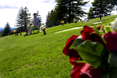 (RNS4-MAY28) Ali Colestaneh, 84, reads the Quran to his deceased wife, Monir, and sister, Iran, at the the gravesites at the Garden of Islam cemetery in Portland, Ore. 