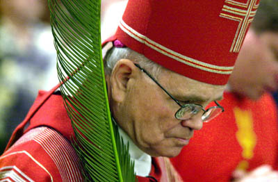 (RNS1-JUNE15) New Orleans Archbishop Alfred Hughes, whose career has been buffeted by the clergy sexual abuse scandal and public anger over post-Katrina downsizing, enters St. Louis Cathedral in a 2003 Palm Sunday procession. For use with RNS-NOLA-BISHOP, transmitted June 15, 2009. Religion News Service photo by Eliot Kamenitz. 