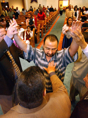 (RNS1-MAY1) Luis Rosas of Holyoke, Mass., is prayed for by Julio Parissi, husband of Carmen Calderon-Parissi, pastor of Movimiento Iglesia Cristiana Pentecostal Church in Holyoke, during a service. Religion News Service file photo by Mieke Zuiderweg. 
