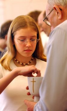 Some churches are modifying their worship practices, including a shared Communion chalice or hugs and handshakes at the sign of peace, in an effort to stem the spread of swine flu. Religion News Service file photo by Lynn Ischay. 