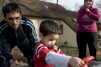 (RNS1-NOV11) Atif Qarni, shown here pushing his 3-year-old son Zane as his wife, Fatima Pashaei looks on, said that he had no qualms about being a Muslim serving in the U.S. military. Maj. Nidal M. Hasan, the Muslim accused of shooting 13 people at Fort Hood, Texas, was reportedly conflicted about whether going to war in majority-Muslim countries was a breach of his faith. See RNS-MUSLIMS-ARMY, transmitted Nov. 11, 2009. Religion News Service photo by Christopher Rossi. 