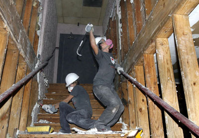 (RNS2-MAR17) University of Central Florida students Katie Neill, left, and Mitch Froelich, right, remove walls in a building that once housed a disco in New Orleans. Some 500 students from various colleges, working through Rebuilding New Orleans Together, are experiencing an alternative spring break as they descend on the area for several days to help repair buildings damaged by Hurricane Katrina. RNS file photo by Eliot Kamenitz/The Times-Picayune. 