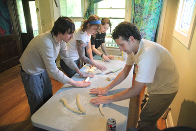 (RNS2-MAY25) Learning the art of making challah bread are, front to back, Jeremy Koosed, Mallory Shwab, and Jessi Malicki, led by Taliesin Haugh, right. Moishe House is a sort of four-bedroom kibbutz, part of a movement to retain Jewish culture among young adults. For use with RNS-MOISHE-HOUSE, transmitted May 25, 2010. RNS photo by Thomas Ondrey/The Plain Dealer. 