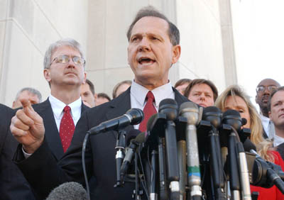 (RNS) A defiant Roy Moore speaks to the press Nov. 13, 2003, outside the judicial building in Montgomery, Ala., after a court ruling that stripped Moore of his position as Alabama Chief Justice. Moore, who came under fire for refusing to remove a public monument of the Ten Commandments, is running his second campaign for governor. RNS file photo by Charles Nesbitt. 
