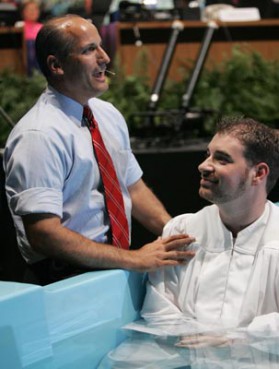 (RNS) Poly Rouse, left, pastor of Hermitage Hills Baptist Church in Hermitage, Tenn., baptizes musician Eric Kilby, during the Southern Baptist Convention's 2005 assembly in Nashville. A years-long decline in baptisms has many Southern Baptists concerned about the vitality of the denomination. RNS file photo courtesy Matt Miller/Baptist Press. 