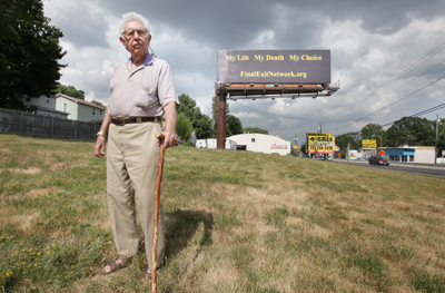 (RNS1-JUL16) Robert J. Levine of Princeton, N.J., who volunteers for the New Jersey chapter of The Final Exit Network, in front of the group's billboard in Hillside, N.J., which has been condemned by the Catholic Church. For use with RNS-DEATH-BOARD, transmitted July 16, 2010. RNS photo by Jerry McCrea/The Star-Ledger. 