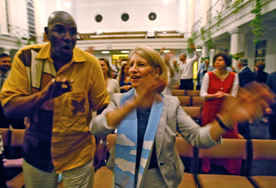 (RNS2-JUL08) The Rev. Gerald Durley, pastor of Atlanta's Providence Missionary Baptist Church, and the Rev. Sally Bingham of Interfaith Power and Light in San Francisco sway to the music during an interfaith service in New Orleans to promote recovery from the BP oil spill in the Gulf of Mexico. For use with RNS-SPILL-SIN, transmitted July 8, 2010. RNS photo by Ted Jackson/The Times-Picayune. 