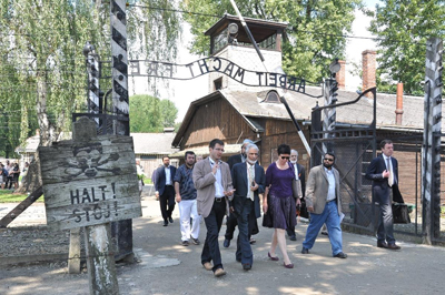 (RNS1-AUG17) Prominent American Muslim leaders and others walk through the gate of the Auschwitz concentration camp as part of a tour of Holocaust sites for Muslims leaders. For use with RNS-HOLOCAUST-MUSLIM, transmitted Aug. 17, 2010. RNS photo courtesy Auschwitz-Birkenau State Museum, via the Star-Ledger. 