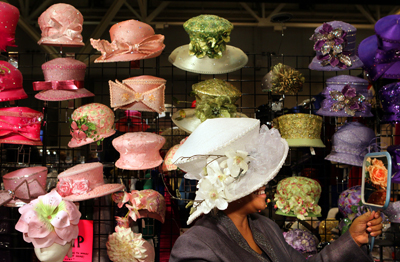 (RNS5-NOV16) Extravagant hats are a fashion staple among attendees at the 103rd Holy Convocation of the Church of God in Christ in St. Louis. Mildred Haygood of Kentucky shopped the vendor booths to try on a few. For use with RNS-CHURCH-HATS, transmitted Nov. 16, 2010. RNS photo by Robert Cohen/The Post-Dispatch. 