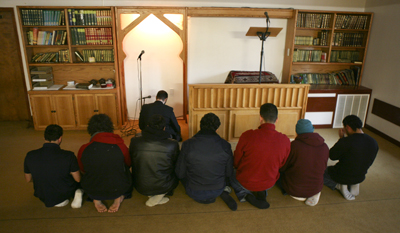 (RNS4-NOV30) Worshippers at the Salman Alfarisi Islamic Center in Corvallis, Ore., led by Imam Yosof Wanly, pray after a former member of the mosque was charged with plotting to set off a car bomb in downtown Portland. For use with RNS-MOSQUE-SUPPORT, transmitted Nov. 30, 2010. RNS photo by Ross William Hamilton/The Oregonian. 