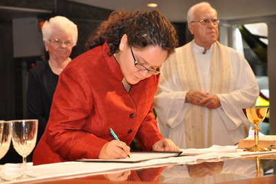 (RNS1-FEB08) Sister Jenn Graus signs her first vows as a new Sister of St. Joseph in LaGrange, Ill. Graus said her parents were initially hesitant about her decision to become a Catholic sister. For use with RNS-NUNS-PARENTS, transmitted Feb. 8, 2011. RNS photo courtesy Sister Joellen Sbrissa/Congregation of St. Joseph. 