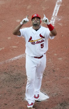 (RNS1-FEB24) St. Louis Cardinals' Albert Pujols celebrates as he crosses home plate with a grand slam against the Chicago Cubs; some Christian fans wonder whether Pujols' evangelical faith conflicts with his quest for a $200 million-plus contract. For use with RNS-PUJOLS-PAYDAY, transmitted Feb. 24, 2011. RNS photo by Chris Lee/The St. Louis Post-Dispatch. 