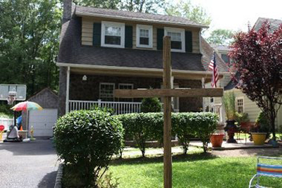 (RNS-AUG05) A wooden cross sits outside the home of Patrick Racaniello, resident of Livingston, NJ.  For use with RNS-CHURCH-FIGHT.  Transmitted August 05, 2011.  Courtesy the Star-Ledger. 