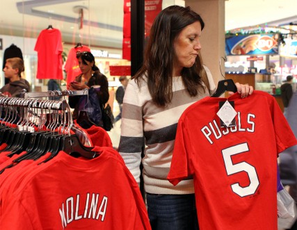 (RSN1-DEC12) Sharon Cool of Lake St. Louis, Mo., picks up a free Cardinals T-shirt with Albert Pujols' name and number on the back at the Pro Image store at the Chesterfield Mall in Chesterfield, Mo. The shirts were given away after Pujols signed with the Los Angeles Angels of Anaheim, Calif., and a local church collected them for charity. For use with RNS-PUJOLS-ANGER, transmitted Dec. 12, 2011. RNS photo by Stephanie S. Cordle/The St. Louis Post-Dispatch. 