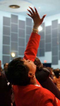 A worshipper reaches her hand heavenward during Believers Night services at The Word church in Maple Heights, Ohio.  