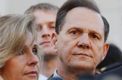 (RNS2-NOV14) Roy Moore (right) and his wife Kayla after hearing the Nov. 13 verdict that 
stripped Moore of his position as Alabama Chief Justice. See RNS-COMMANDMENT-JUDGE, 
transmitted Nov. 13, 2003. Photo by Charles Nesbitt. 