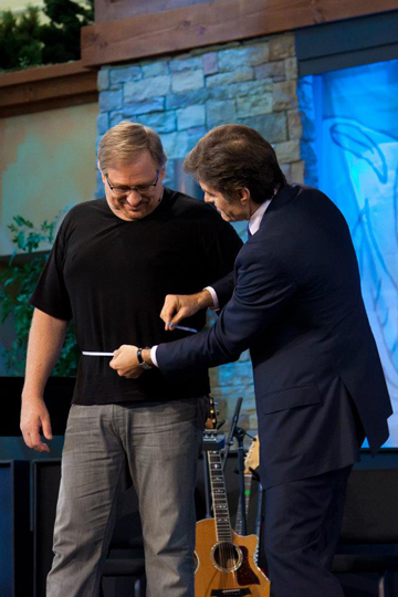 Dr. Mehmet Oz measures megachurch pastor Rick Warren's waisteline at a "Daniel Plan" forum at Saddleback Church in Lake Forest, Calif. Warren has already lost 60 pounds, and hopes to lose 30 more using the faith-based diet plan. RNS photo courtesy Toby Crabtree/Saddleback Church  