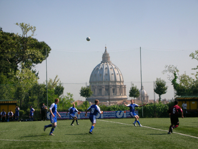Members of the Pontifical North American College soccer team (in blue) play the Pontifical Gregorian University in Rome in 2007, with St. Peter's Basilica in the background. The teams 
are participants in the Clericus Cup, which lost its Vatican-sponsorship. Religion News Service photo by Francis X. Rocca.