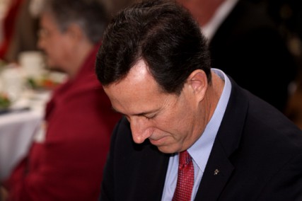 Presidential candidate Rick Santorum bows in prayer during a campaign rally in Phoenix, Ariz. 