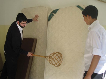 Two Orthodox Jewish Jerusalemites clean their mattresses ahead of the Passover holiday.  