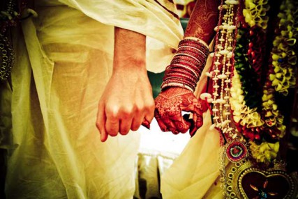 Bride and groom hold hands during a Hindu wedding ceremony. 