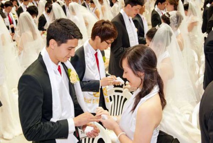 A couple exchanges rings during a mass wedding ceremony arranged by the Unification Church in Korea on March 24, 2012. 