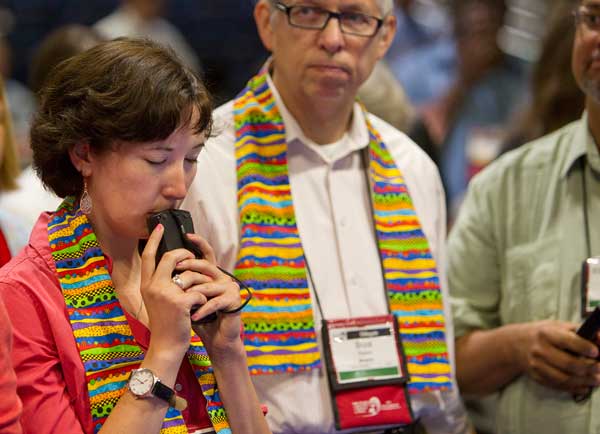 Delegate Sara Ann Swenson (left) of Minnesota presses her voting keypad to her lips while awaiting results of a vote on the United Methodist Church's stance on sexuality during the denomination's 2012 General Conference in Tampa, Fla. At center is fellow delegate the Rev. Bruce Robins. Photo by Mike DuBose/courtesy United Methodist News Service