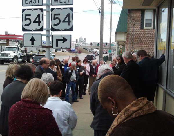 Clergy and staff from across Missouri gather in front of a payday loan shop in Jefferson City to pray for efforts to cap the rate lenders can charge in Missouri. The average annual percentage rate in the state is about 444 percent. Religious leaders are pushing for a ballot initiative to cap the rate at 36 percent. RNS photo by W.T. Edmonson