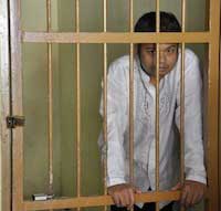 The atheist community has embraced the cause of an Indonesian man, Alexander Aan (pictured here behind bars), who was beaten and jailed after denying God’s existence on Facebook and posting cartoons of the Prophet Muhammad. 