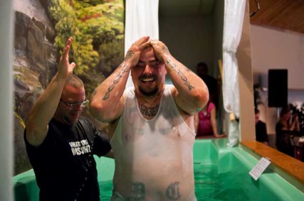 Chris Simpson wipes away water from his face after being baptized by New Horizons Community Church pastor Jerry Lyons Sunday morning, April 15. 