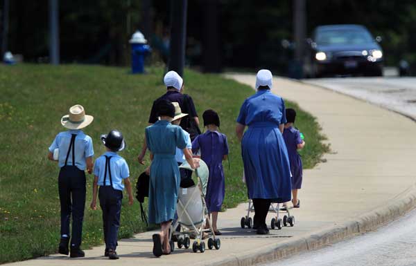 An Amish family walks on Springdale Ave. after visiting the Harrington Square shopping plaza in Middlefield August 2, 2012. 