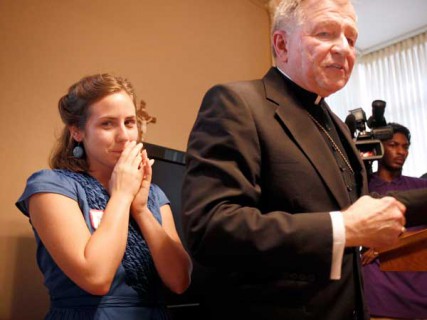 Paige LaCour, left, stands behind Archbishop Gregory Aymond, right, during the opening of the Magnificat House of Discernment for Women in New Orleans, Louisiana, Wednesday, August 15, 2012. It was a conversation the archbishop had with LaCour that began the idea for the Magnificat House of Discernment for Women. 
