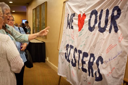 Attendees admire a 'We (heart) Our Sisters' sign hanging outside of the Leadership Conference of Women Religious in St. Louis, Mo. on Friday, August 10, 2012. 