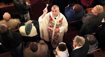Fr. Sandor Siklodi blesses the people with holy water during the reopening mass at St. Emeric Catholic Church November 4, 2012. Siklodi was the former pastor of the church who was brought back from Chicago. St. Emeric is the eleventh and final church to reopen. 