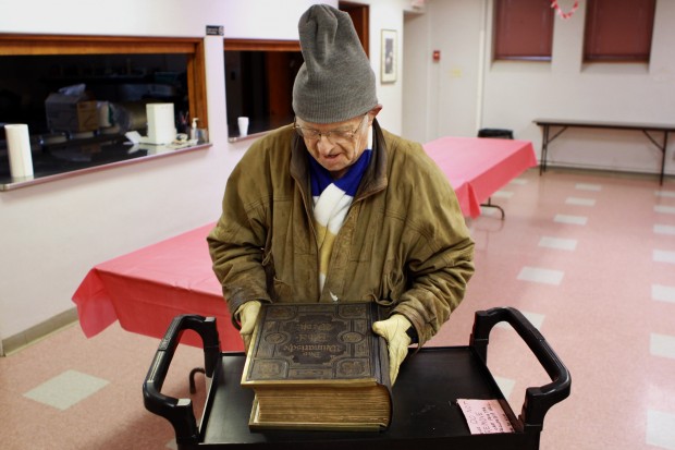 St. Johns Lutheran Church parishioner and volunteer Karl Frerichs, of St. Louis, prepares to lock up an antique Bible that was recently stolen and then returned to the St. Louis church on Wednesday, Dec. 26, 2012. RNS photo by Huy Mach/St. Louis Post-Dispatch
