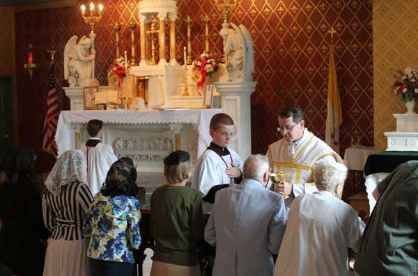 Father Kevin Robinson distributes Communion during a traditional Latin Mass at St. Michael the Archangel Chapel in Farmingville, N.Y., June 17. The chapel is administered by the Society of St. Pius X. RNS photo by Gregory A. Shemitz 