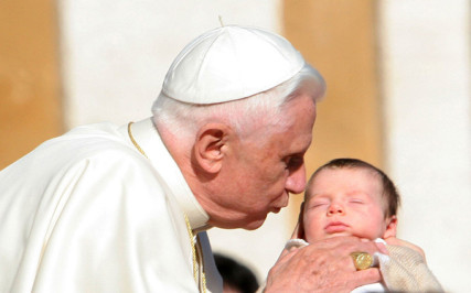 Pope Benedict XVI kisses an infant as he leaves one of his weekly general audience in St. Peter's Square at the Vatican in 2007.  RNS photo by Gregory A. Shemitz.