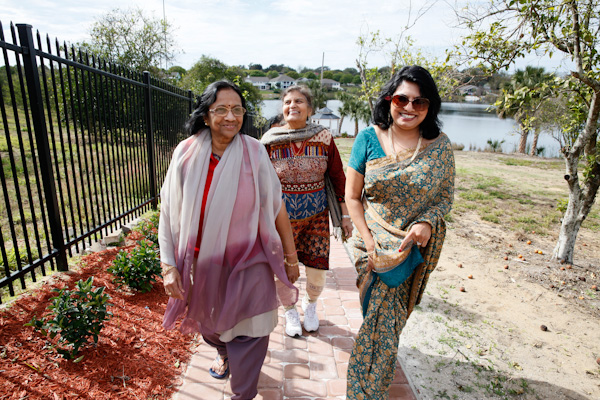 Bindu Sheth, left, Urmila Gandhi, center, and Rani Rajagopal,  walk around the grounds near the lake. ShantiNiketan, located in Tavares, Fl., is a gated retirement community catering to Indian immigrants. Residents dine on vegetarian meals, partake in daily yoga as well as Bhajans (prayer) everyday at noon. Some women dress in traditional sarees and their is a strong sense of community. RNS photo by Julie Fletcher.