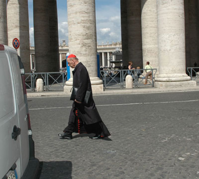 An unidentified Cardinal walking toward the Domus Santa Martha, the hotel where the Cardinals live during the Conclave. Many Cardinals cruise the streets of Rome by chauffered car; but some prefer the old fashioned method of transportation.  Photo by Rene Shaw. 