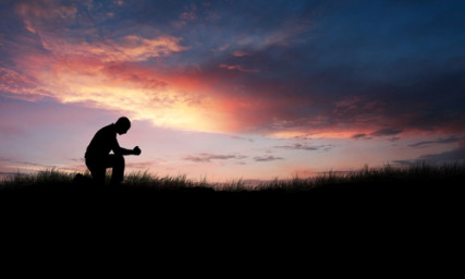Man kneeling down in a field to pray, via Shutterstock.com. http://shutr.bz/W8gIw2