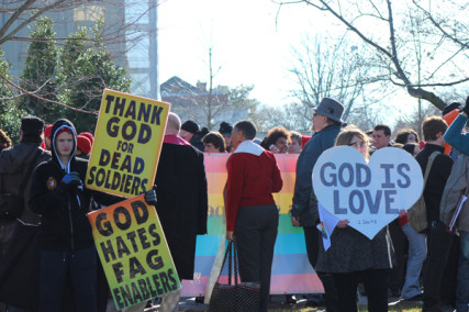 A Westboro Baptist Church sign holder, left, and gay marriage supporter spread their messages outside the Supreme Court on March 26, 2013. Throngs of supporters and opponents gathered outside the high court as it considered cases about same-sex marriage. RNS photo by Adelle M. Banks