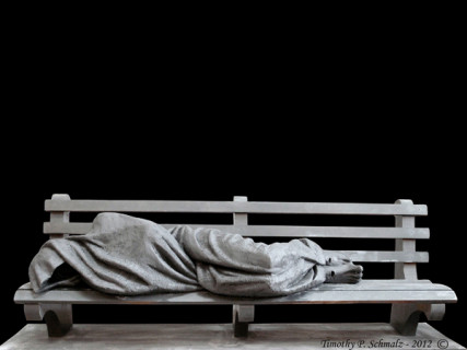 Canadian sculptor Timothy Schmalz notes the ironies in his latest creation, "Jesus the Homeless," a bronze sculpture depicting the Christian savior huddled beneath a blanket on an actual-size park bench. Only the feet are visible, and their gaping nail wounds reveal the subject.  Photo courtesy Timothy Schmalz