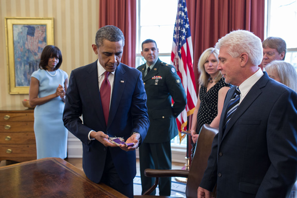 President Barack Obama holds Chaplain (Captain) Emil Kapaun's Easter stole in the Oval Office during a greet with Kapaun's family in the Oval Office, April 11, 2013. The President and First Lady Michelle Obama met with members of Chaplain Kapaun's family before awarding him the Medal of Honor  posthumously during a ceremony in the East Room. Official White House Photo by Pete Souza