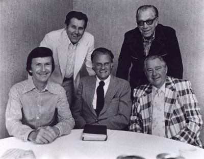 Veteran members of the Billy Graham team who were with the evangelist during his 1952 campaign in Jackson, Miss., pause for a visit before beginning their 1975 Mississippi Crusade. (From left to right) Tedd Smith, pianist; Cliff Barrows, song leader and program director; Graham; George Beverly Shea, soloist; and Grady Wilson, associate evangelist. Religion News Service file photo. 1975