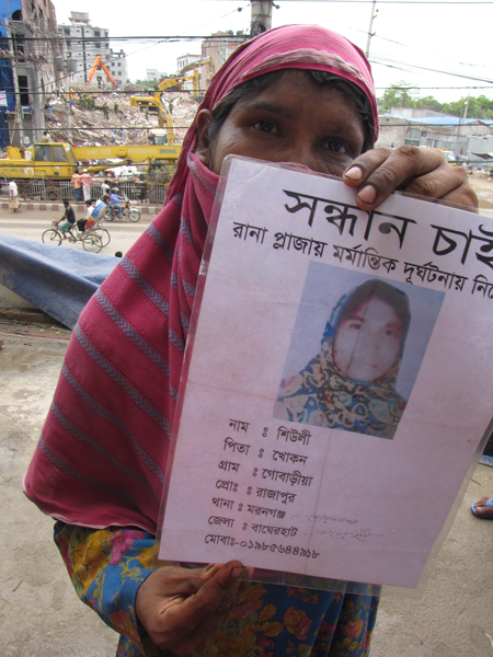 Ranjana Akhter, 35, holds a picture Wednesday of her missing daughter Sheuli Akhter, 20, while standing opposite the ruins of Rana Plaza where Sheuli worked. The building, packed with garment factories on illegally built additional stories, collapsed April 24 in a suburb of the Bangladesh capital Dhaka. Photo by Calum MacLeod/USA Today