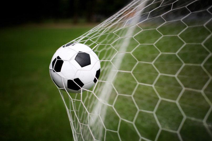 Soccer ball in goal, image courtesy Shutterstock.